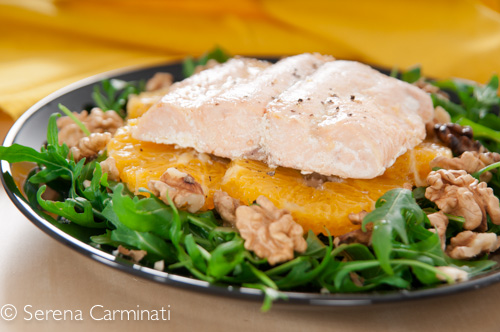Steamed salmon with rocket and oranges (front view, close up)