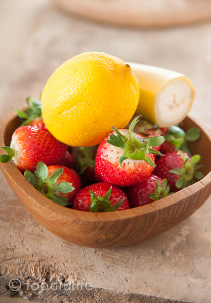 Strawberry and banana smoothy in a glass jar on green napkin, on a wood board, frullato di fragole e banana 