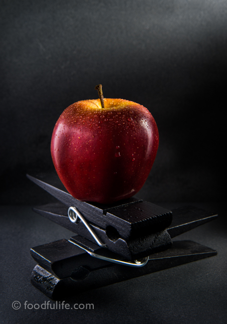 Apple with droplets on clothespins
